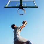 homem fazendo cesta no basquete para ilustrar texto sobre os benefícios do esporte