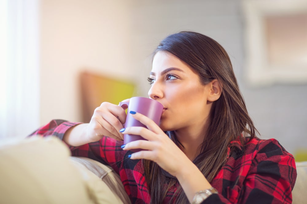 mulher tomando café no home office