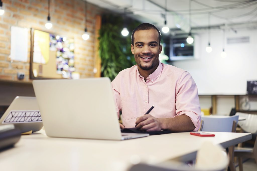 homem sorrindo com notebook