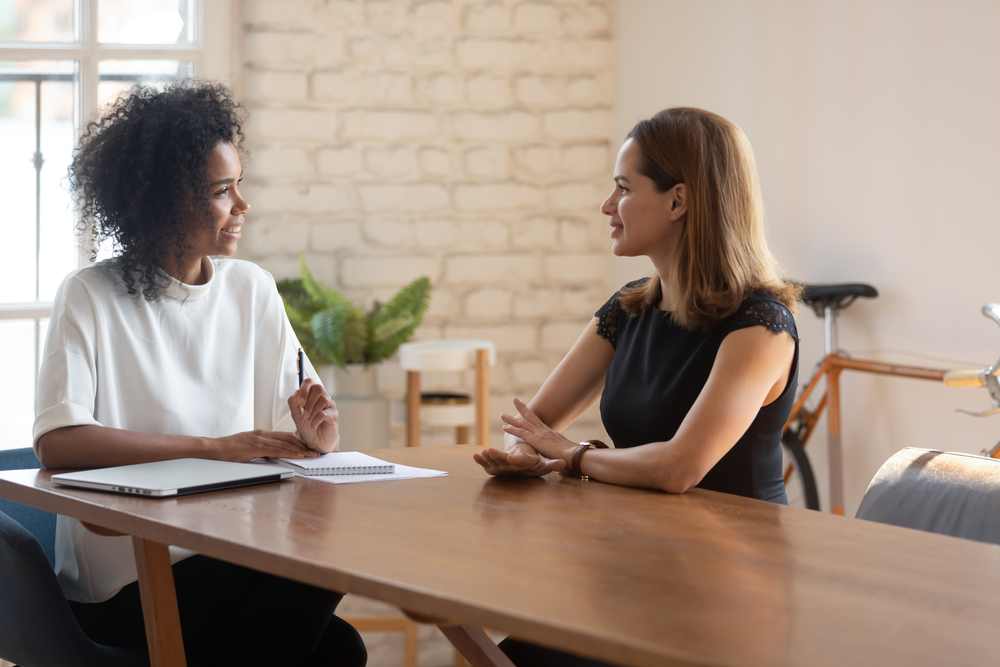 mulheres conversando em uma sala de reunião para ilustrar texto sobre perguntas para fazer ao entrevistador