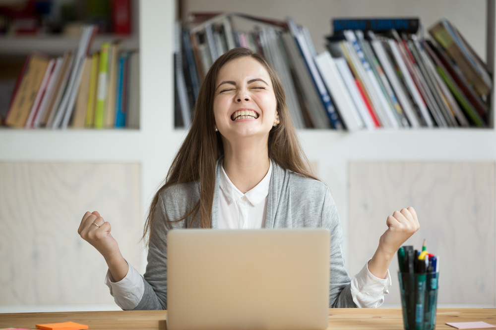 mulher feliz e comemorando promoção no trabalho