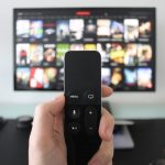 controle remoto com TV de fundo para representar busca por séries