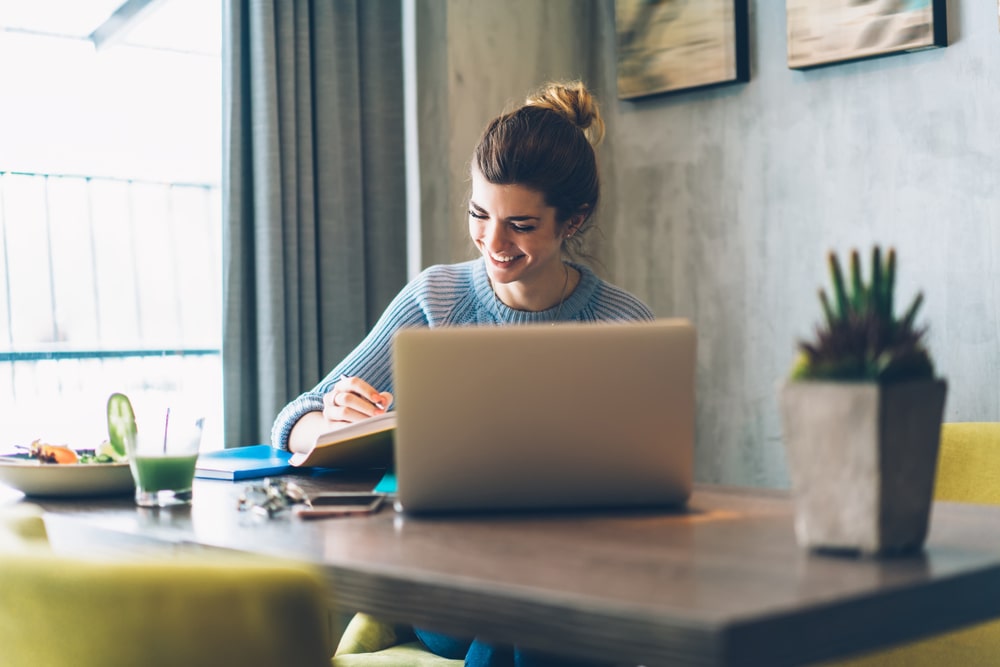 mulher estudando com notebook para ilustrar texto sobre cursos de pós-graduação