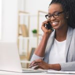 mulher sorrindo no telefone para ilustrar texto sobre motivação no trabalho