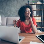 mulher sorrindo no escritório para ilustrar texto sobre significado de profissional qualificado