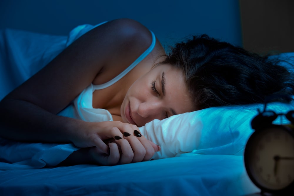 mulher com sono dormindo na cama virada de lado