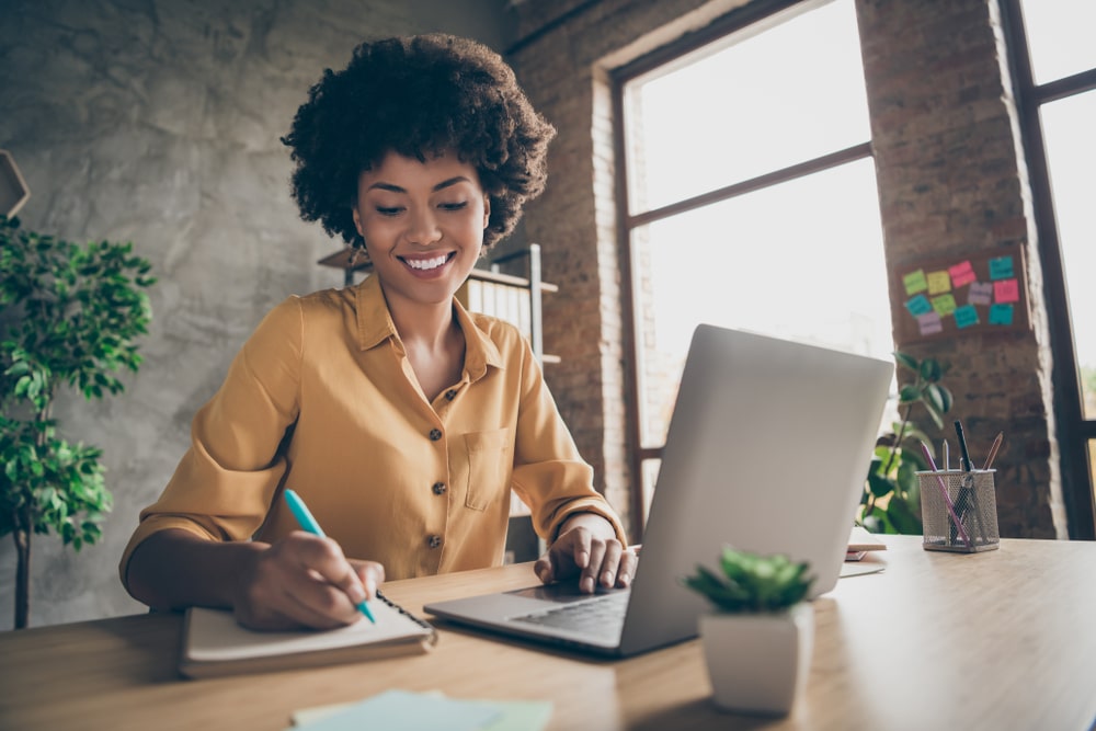 mulher fazendo anotações para ilustrar texto sobre investir em uma pós-graduação