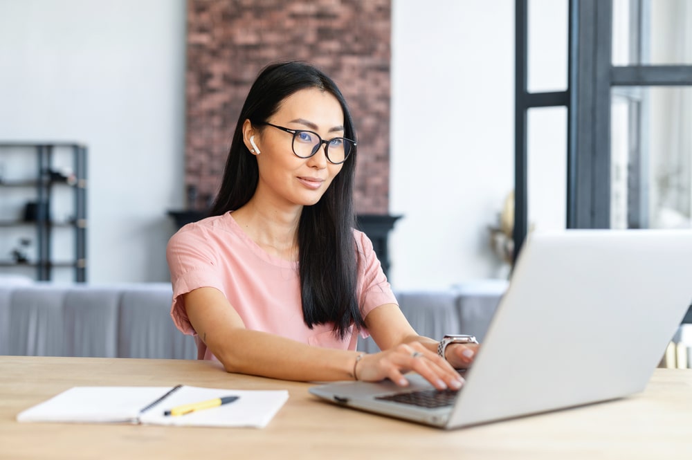 mulher digitando no computador para ilustrar texto sobre significado de versatilidade