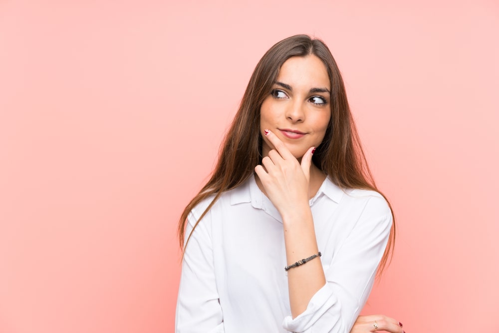 mulher com expressão de dúvida para ilustrar texto sobre pós-graduação e trabalho