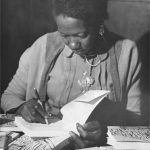 Carolina Maria de Jesus assinando seu livro Quarto de Despejo em 1960