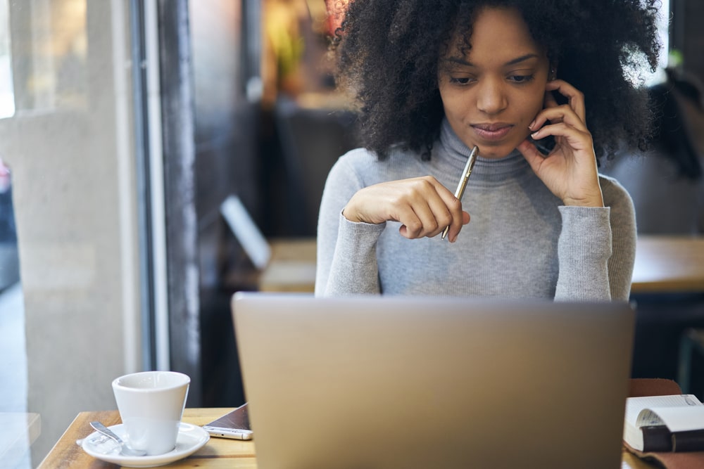 mulher com caneta na mão e notebook para representar texto sobre redator web