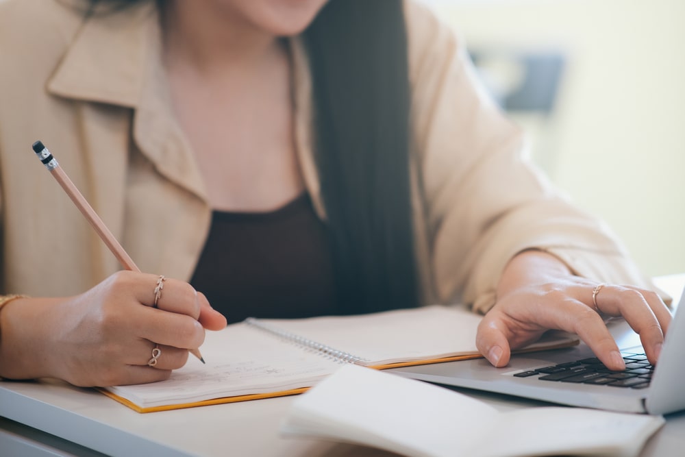 mulher com lápis na mão fazendo anotações para ilustrar texto sobre educação e carreira