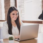 mulher feliz com notebook para ilustrar texto sobre pós-graduação