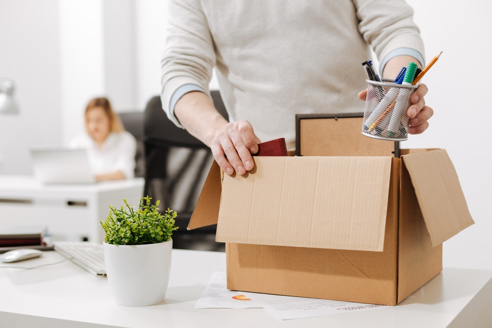 homem guardando objetos em caixa para ilustrar texto sobre processo de offboarding