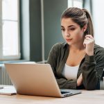 mulher olhando para a tela do notebook para ilustrar texto sobre recebeu uma proposta de emprego