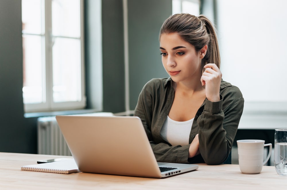 mulher olhando para a tela do notebook para ilustrar texto sobre recebeu uma proposta de emprego