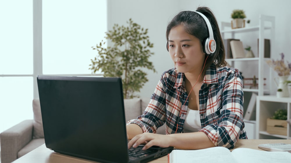 jovem com fone de ouvido e notebook para ilustrar texto sobre tipos de cursos livres