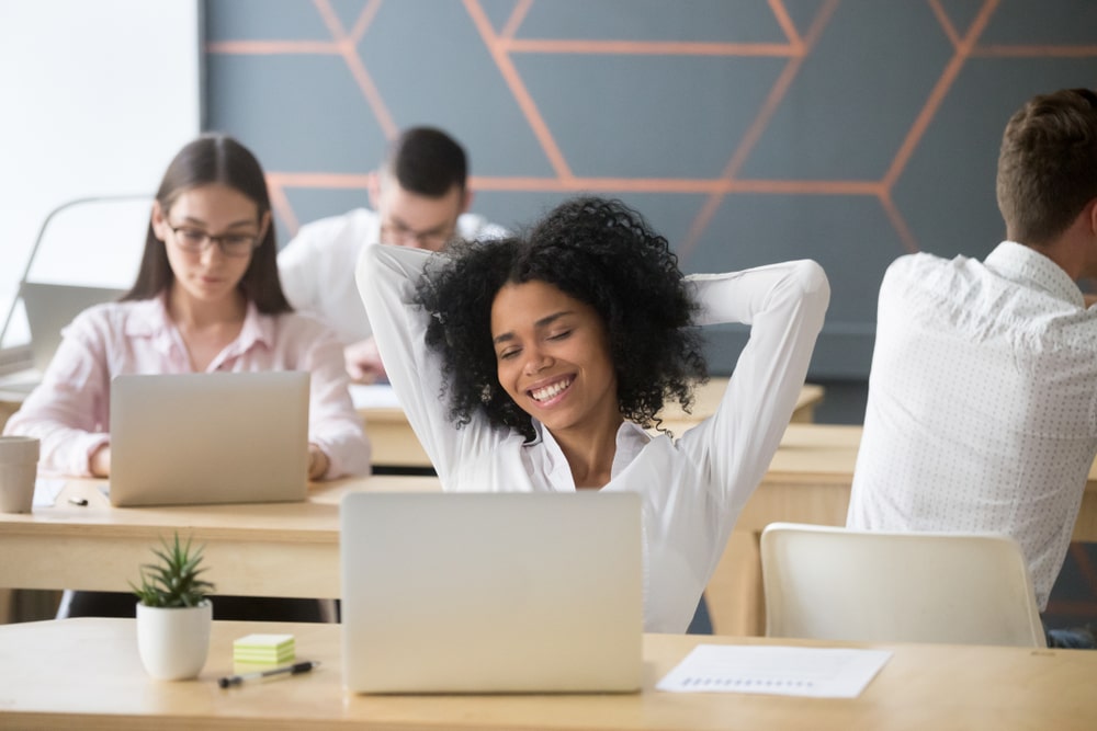 mulher feliz no escritório para ilustrar texto sobre bem-estar corporativo