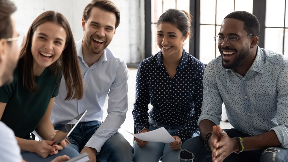 equipe de trabalho sorrindo para ilustrar texto sobre felicidade corporativa