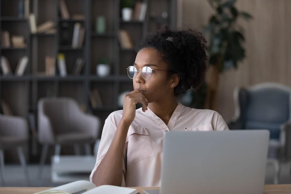 Mulher com expressão pensativa para ilustrar texto sobre quanto tempo dura um MBA