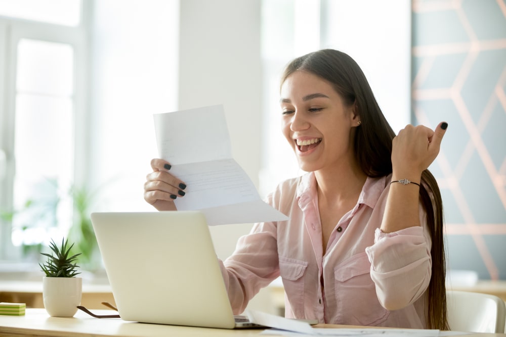 mulher com carta na mão comemorando para ilustrar texto sobre estratégias para conquistar uma promoção