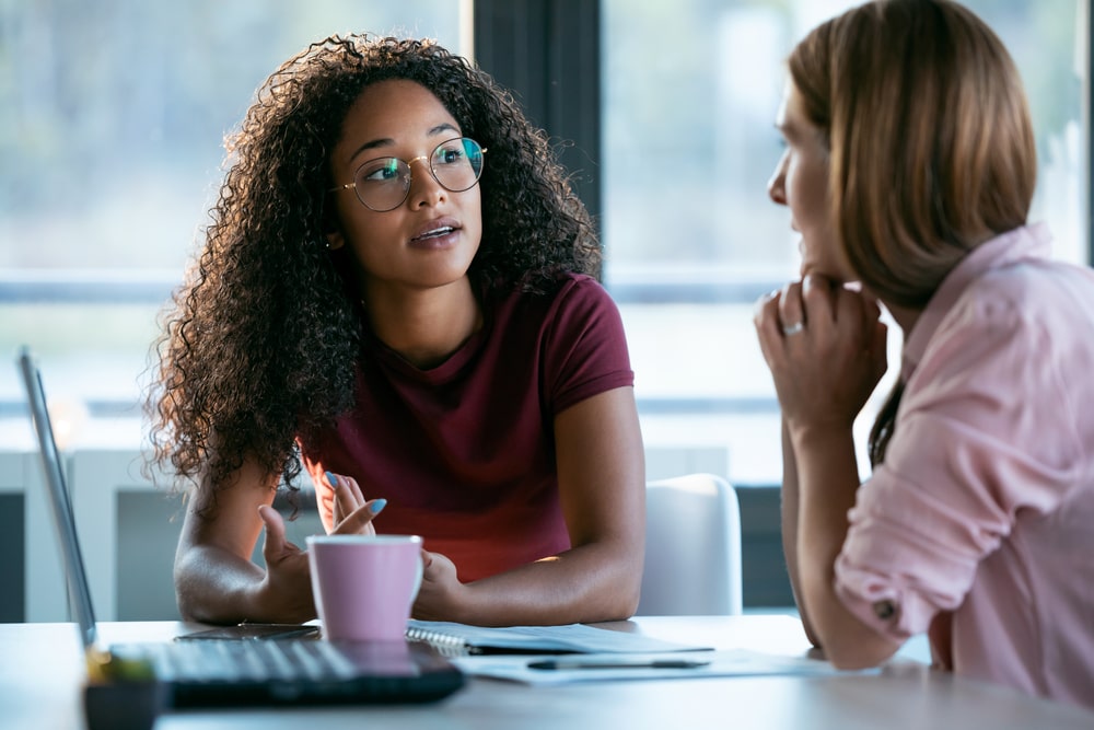 duas mulheres conversando para ilustrar texto sobre como pedir o desligamento da empresa