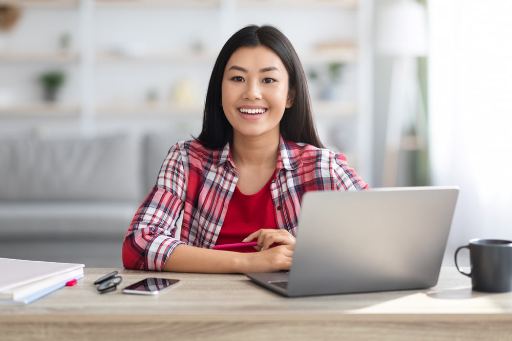 mulher sorrindo para ilustrar texto sobre ser feliz no trabalho