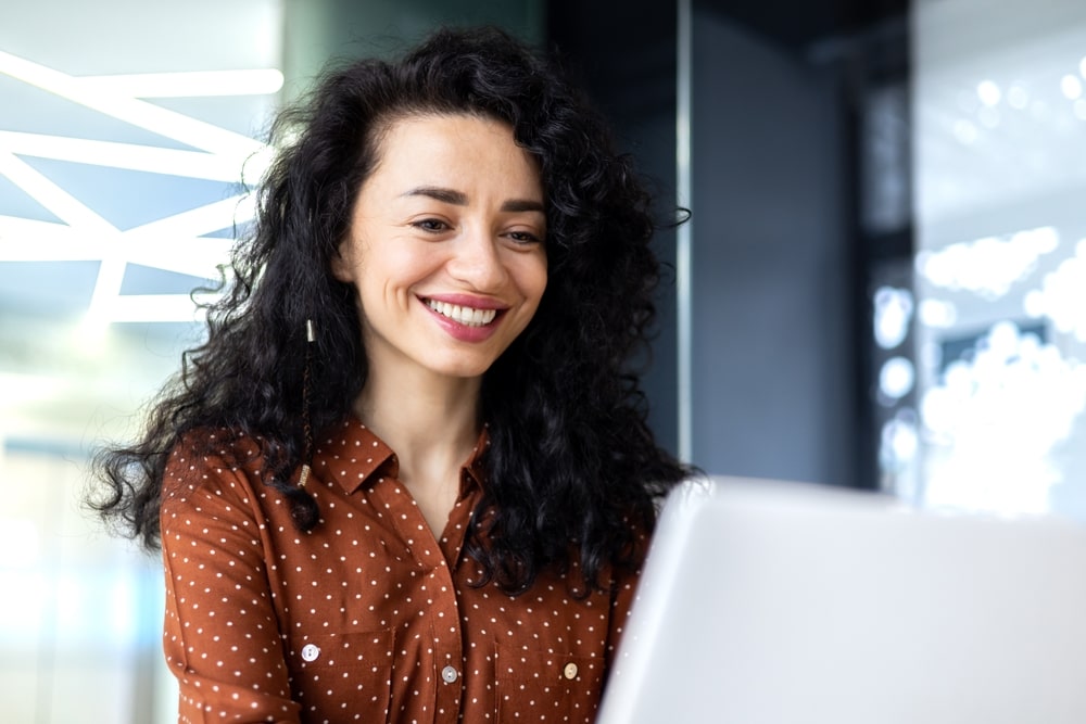 mulher sorrindo para ilustrar texto sobre o que dizer e não dizer numa entrevista de emprego