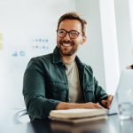 homem sorrindo para ilustrar texto sobre trabalhar com o que gosta