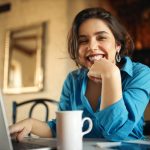 mulher sorrindo com notebook para ilustrar texto sobre acesso vitalício ao curso