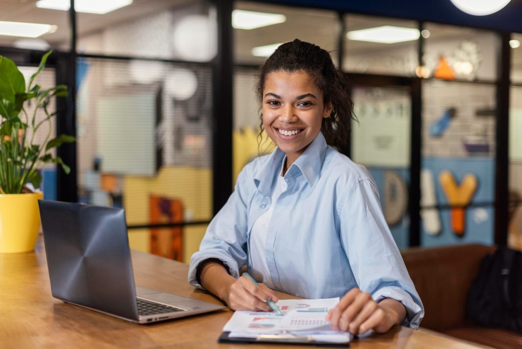 mulher sorrindo no escritório para ilustrar texto sobre talentos qualificados