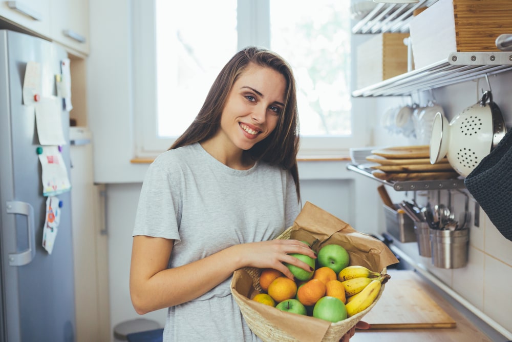 mulher com frutas na mão para ilustrar texto sobre Aulas de pós-graduação com demonstrações práticas