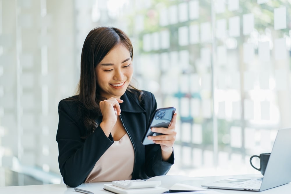 mulher com celular na mão para ilustrar texto sobre quando o recrutador diz que vai ligar, quanto tempo esperar