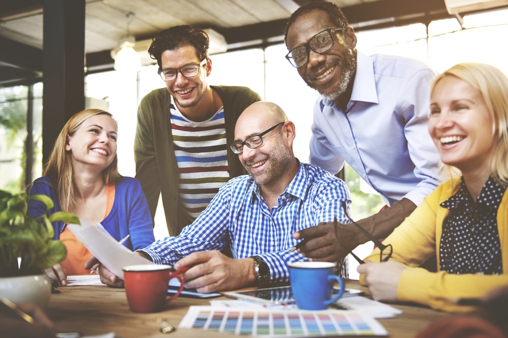 equipe feliz para ilustrar texto sobre como aplicar o índice da Felicidade Interna Bruta nas empresas