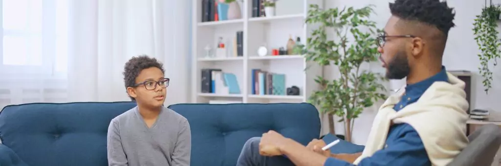 psicólogo com menino em consulta