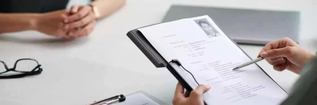 entrevistadora analisando currículo