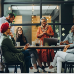 reunião de trabalho em sala de reunião entre pessoas de diversas culturas.