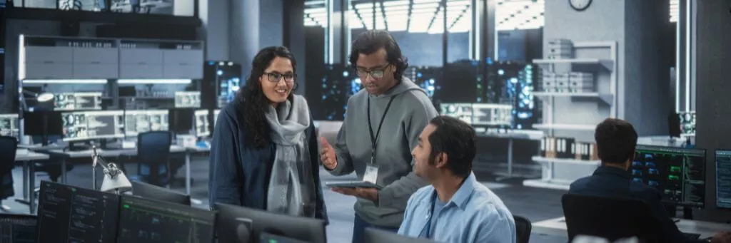 homem explicando algo em tablet para colegas de equipe